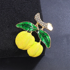 Détail de broche durian avec texture émail jaune et feuilles ornées de cristaux brillants