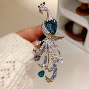 Close-up of luxury silver peacock brooch with blue heart stone and zircon stones
