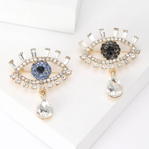 Detail of evil eye brooches with blue crystals and hanging teardrop rhinestones