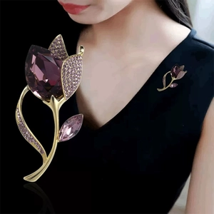 Close-up of elegant purple crystal tulip brooch featuring a faceted gemstone on a black lapel