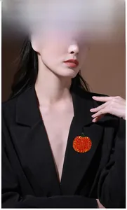 Rote Kürbis-Brosche mit Kristallen am schwarzen Revers für ein festliches Styling