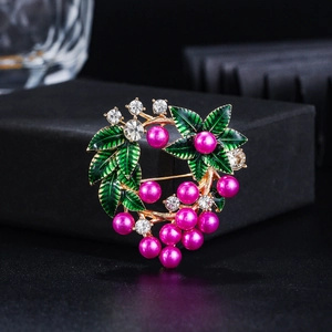Détail de la broche couronne florale avec perles roses, émail vert et strass