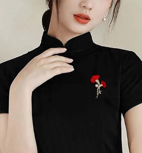 Detailansicht der eleganten roten Nelkenbrosche mit Perlen auf schwarzem Cheongsam
