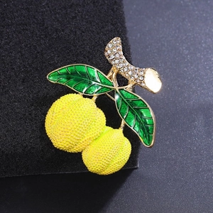 Broche fruitée avec baies jaunes texturées et feuilles en émail vert sur monture dorée