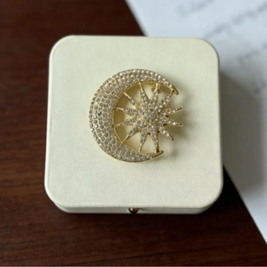 Celestial sun and moon brooch with crystals in a premium gift box on wood