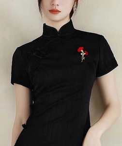 Eleganter roter Nelken-Anstecknadel mit goldenen Stielen und Perle auf schwarzem Kleid