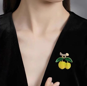 Broche citron créative avec émail jaune et feuilles vertes sur costume en velours