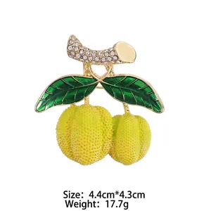 Broche créative en forme de durian doré avec feuilles en émail vert et strass brillants