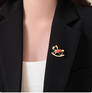 Exquisite hollow rocking horse brooch in gold with red enamel and sparkling rhinestones