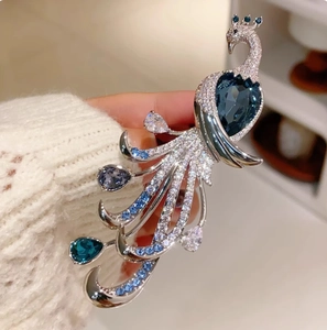 Elegant silver peacock brooch with sparkling deep blue crystals and waterdrop gemstone