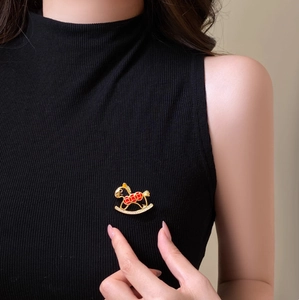 Exquisite gold-plated rocking horse brooch with red enamel and sparkling rhinestones