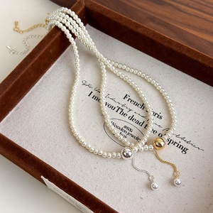 Classic double-layer pearl necklace with brushed gold and silver tassel pendants