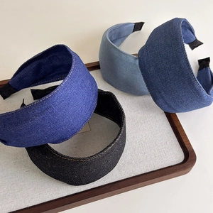 Detail of wide denim headbands in blue and black with textured fabric and contrast stitching