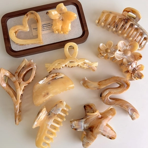 Brown amber hair claws in heart and floral shapes with acetate texture on a tray