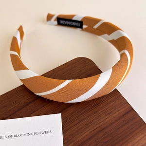 Detailed view of the handmade label and orange striped fabric texture on the headband