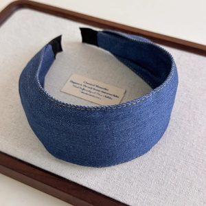 Close-up of blue denim headband with decorative double yellow stitching details