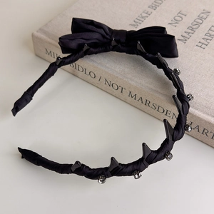 Detail of black satin bow headband with non-slip teeth and sparkling rhinestone studs