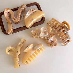 Detailed set of 6 amber marbled hair claws in various elegant resin and acrylic shapes