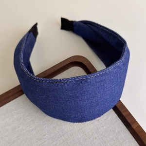 Close-up of blue denim hair hoop with yellow stitching and comfortable black fabric ends