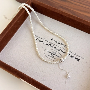 Detail of Y-shape pearl necklace with adjustable metal ball and drop pearl pendant