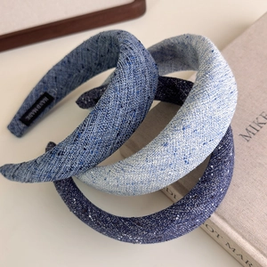 Detail of four padded blue tweed headbands showing handmade labels and denim texture