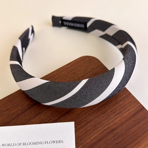 Detail of striped sponge headband featuring a handmade label and twill fabric texture