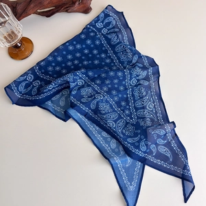 Detailed macro view of dark blue paisley silk scarf with vintage floral patterns