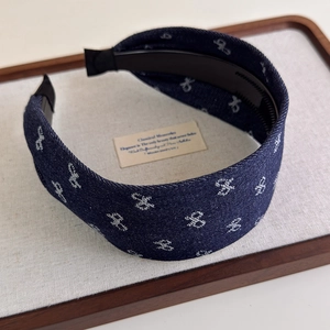 Detail view of denim headband with floral embroidery and non-slip inner teeth design