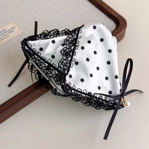 Detail of satin polka dot lace hair clip with black ribbon bow and elegant pearl charm
