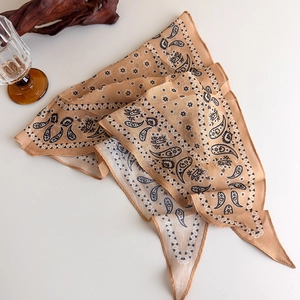 Detail shot of a vintage brown paisley cotton scarf displayed with rustic wooden decor