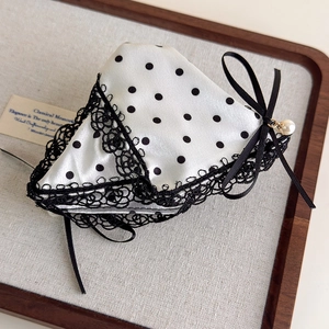 Detailed view of satin polka dot bow hair claw with lace trim and elegant pearl pendant