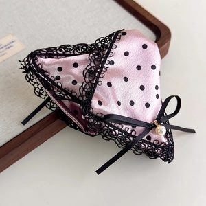 Detailed view of pink satin hair claw with black polka dots, lace trim and pearl pendant