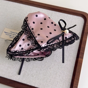 Detail of pink satin hair claw with black polka dots, lace edges and pearl bow