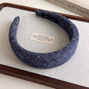 Detailed close-up of handmade navy blue tweed headband with authentic hand made label