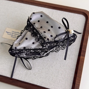 Detailed shot of satin polka dot hair claw with lace trim and elegant pearl pendant