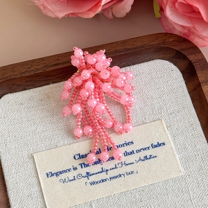 Dettaglio macro del ciondolo fiore rosa perlato con nappe di cristallo per zoccoli