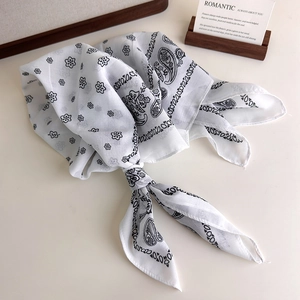 Detail of soft cotton paisley bandana scarf with floral patterns in white and black