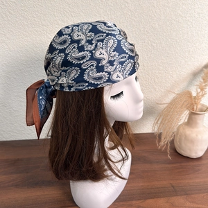 Detail of navy blue silk-like paisley bandana styled on hair with elegant cashew patterns