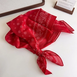 Detailed macro shot of red paisley pattern cotton scarf with white floral motifs