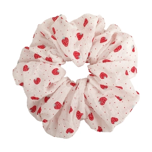 Detail von süßem Erdbeermuster Scrunchie mit roten Punkten und weichem, gerafftem Stoffgewebe