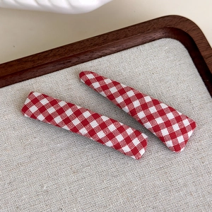 Detail of red and white checkered fabric hair clips on a wooden tray set of two