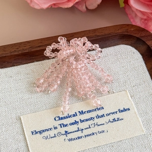 Dettaglio di fiocchi in perline di cristallo rosa con nappe per decorazione sabot