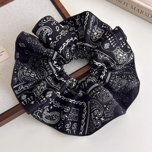 Detail of vintage black paisley pattern fabric scrunchie with fine stitched edges