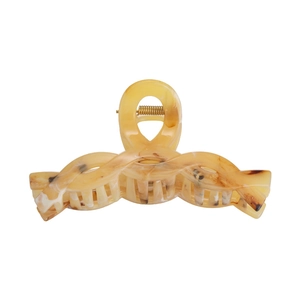Detail view of large amber hair claw clip with cream marbled texture and gold spring