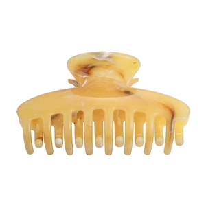 Detailed view of yellow marble textured hair claw clip with strong spring grip