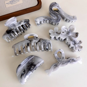 Detail showing set of six grey ink marble hair claws in various geometric shapes
