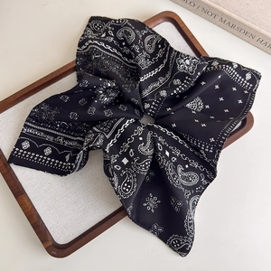 Detail of vintage black and white paisley print fabric with soft silk texture and folds