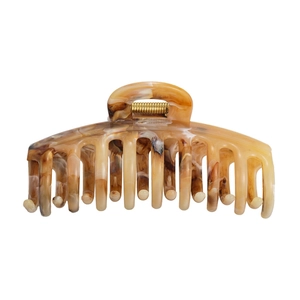 Macro detail of amber tortoiseshell hair claw clip with strong gold metal spring