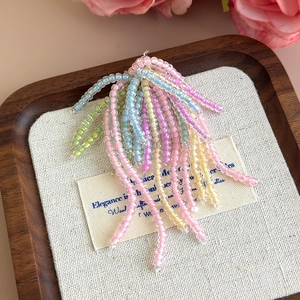 Dettaglio di ciondoli a fiori in perline color pastello per decorare scarpe jelly