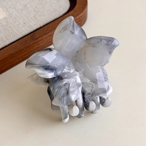 Close-up of a large flower hair claw clip with grey and white marble ink texture
